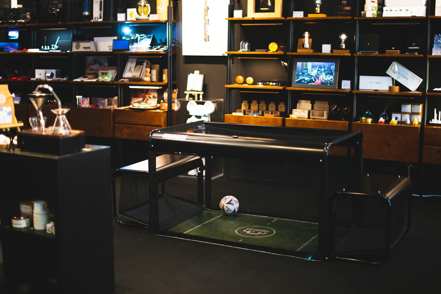 Modern showroom with product displays and soccer table.