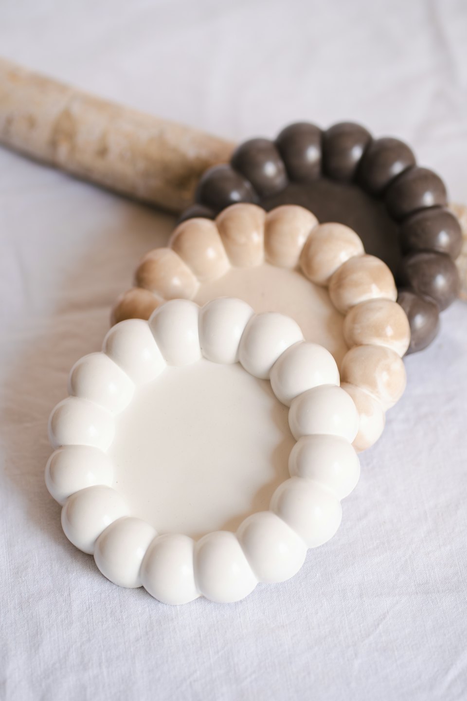 Three stacked circular decorative coasters with bubbly scalloped edges.